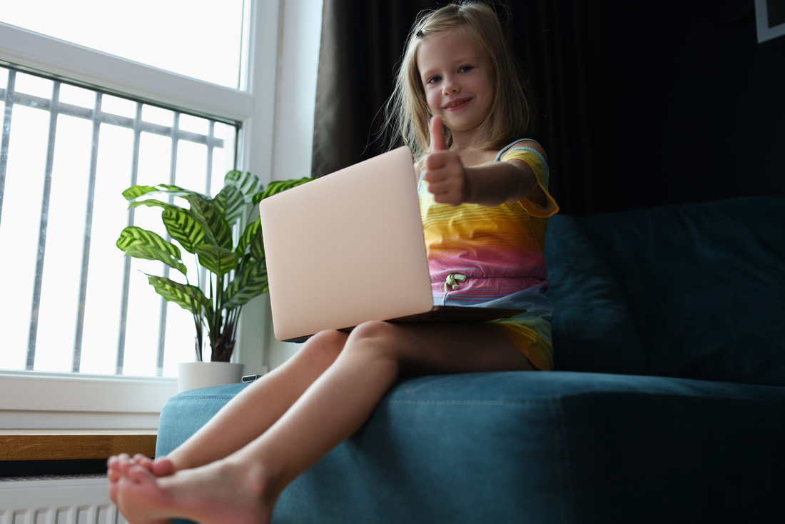 Girl sitting on the couch holding a laptop